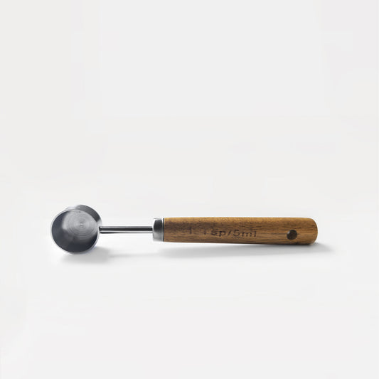 vista lateral del scoop pura prote 5 ml vacío, puño de madera y acero inoxidable