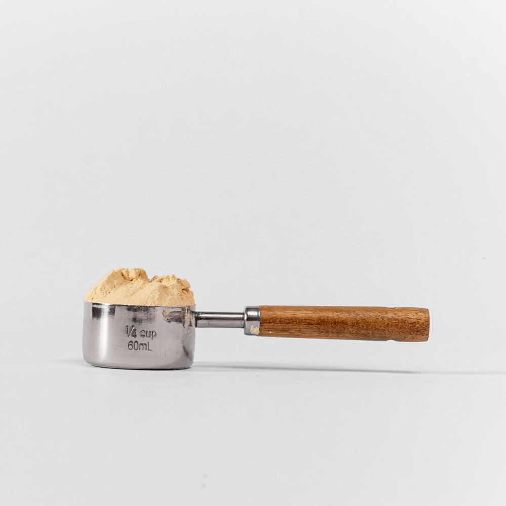 vista lateral de scoop pura prote 60 ml con polvo de proteina de arveja organica
