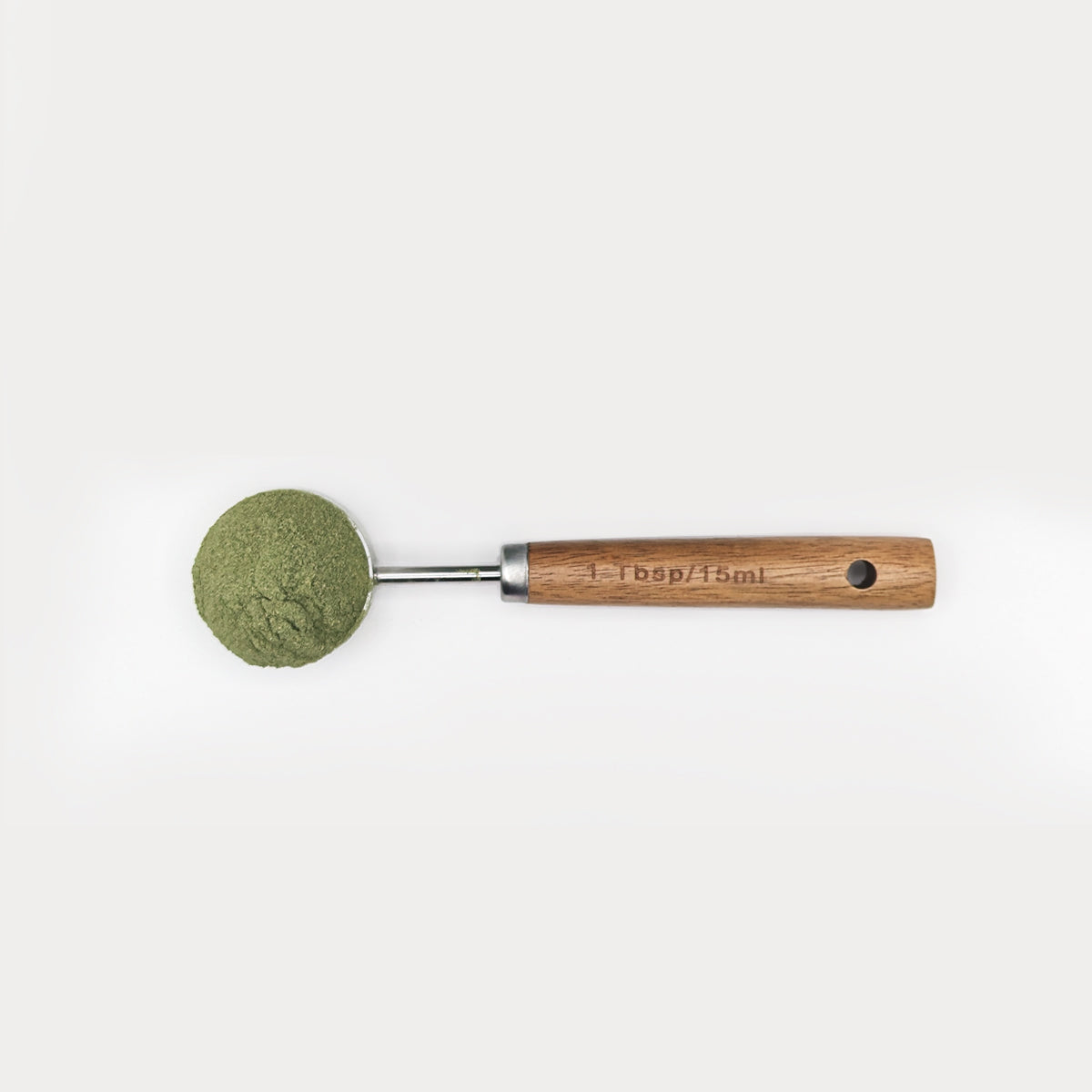 foto area del scoop pura prote 15 ml, hecho de puño de madera y acero inoxidable, con polvo de verdes organicos