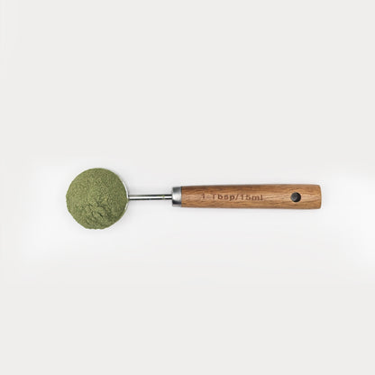 foto area del scoop pura prote 15 ml, hecho de puño de madera y acero inoxidable, con polvo de verdes organicos