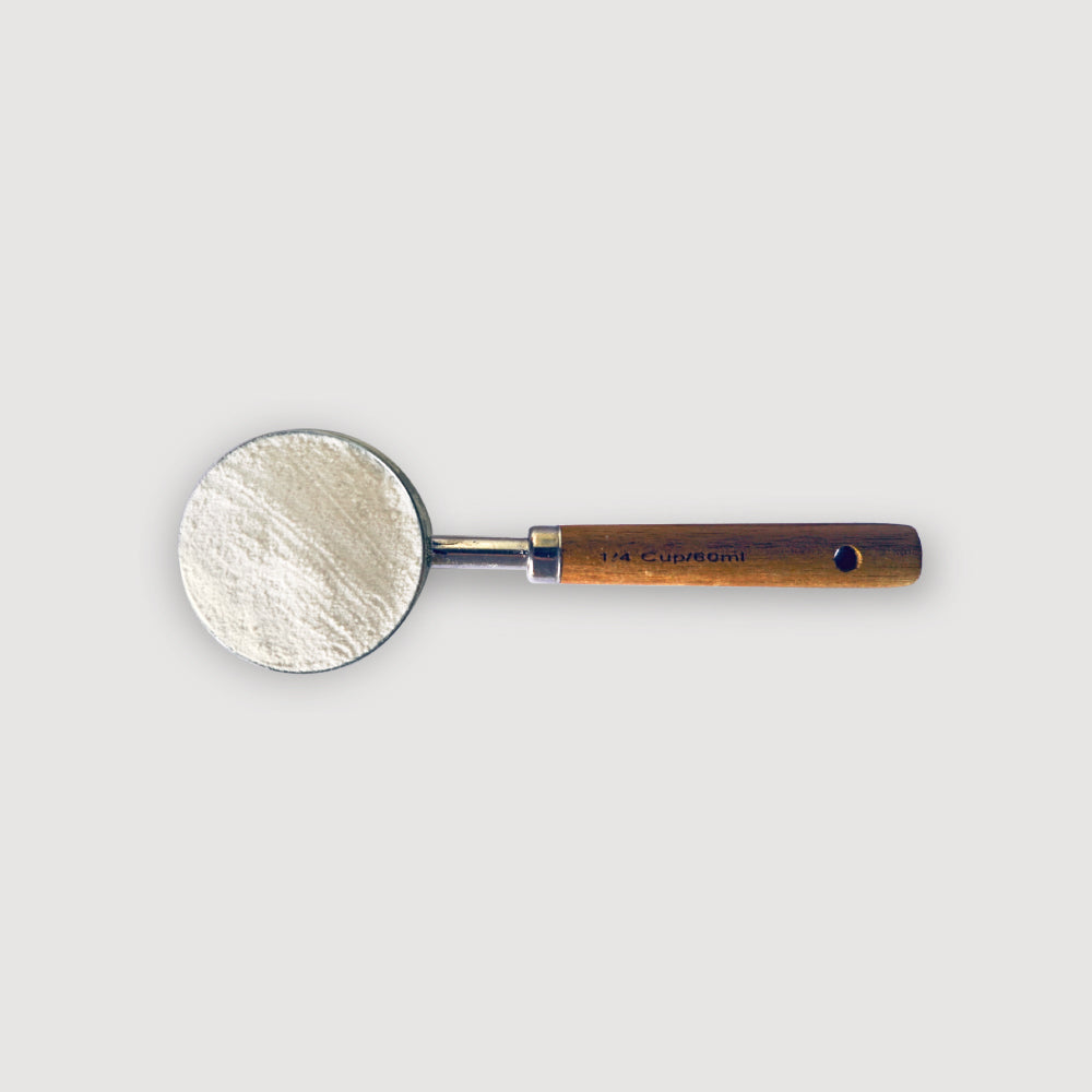 foto area del scoop pura prote 60 ml, hecho de puño de madera y acero inoxidable, con polvo de proteina ISO limpio