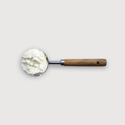 foto area del scoop pura prote 60 ml, hecho de puño de madera y acero inoxidable, con polvo de proteina whey limpio
