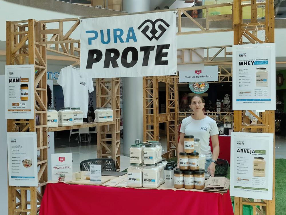 foto de cofundadora en una feria con productos pura prote