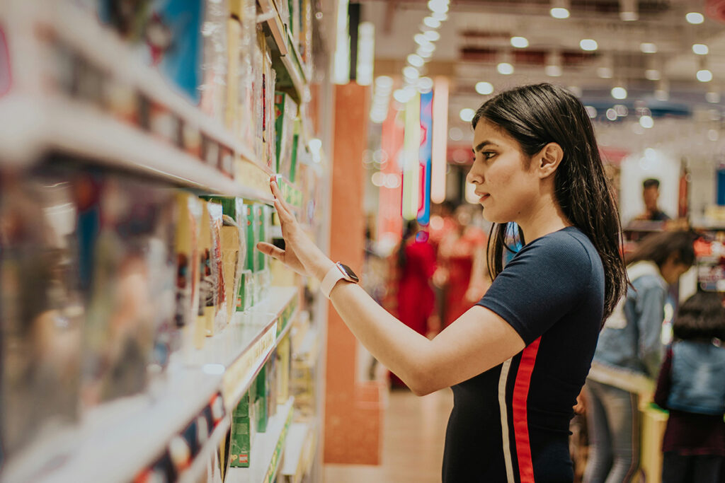 Mujer leyendo etiquetas en un supermercado.