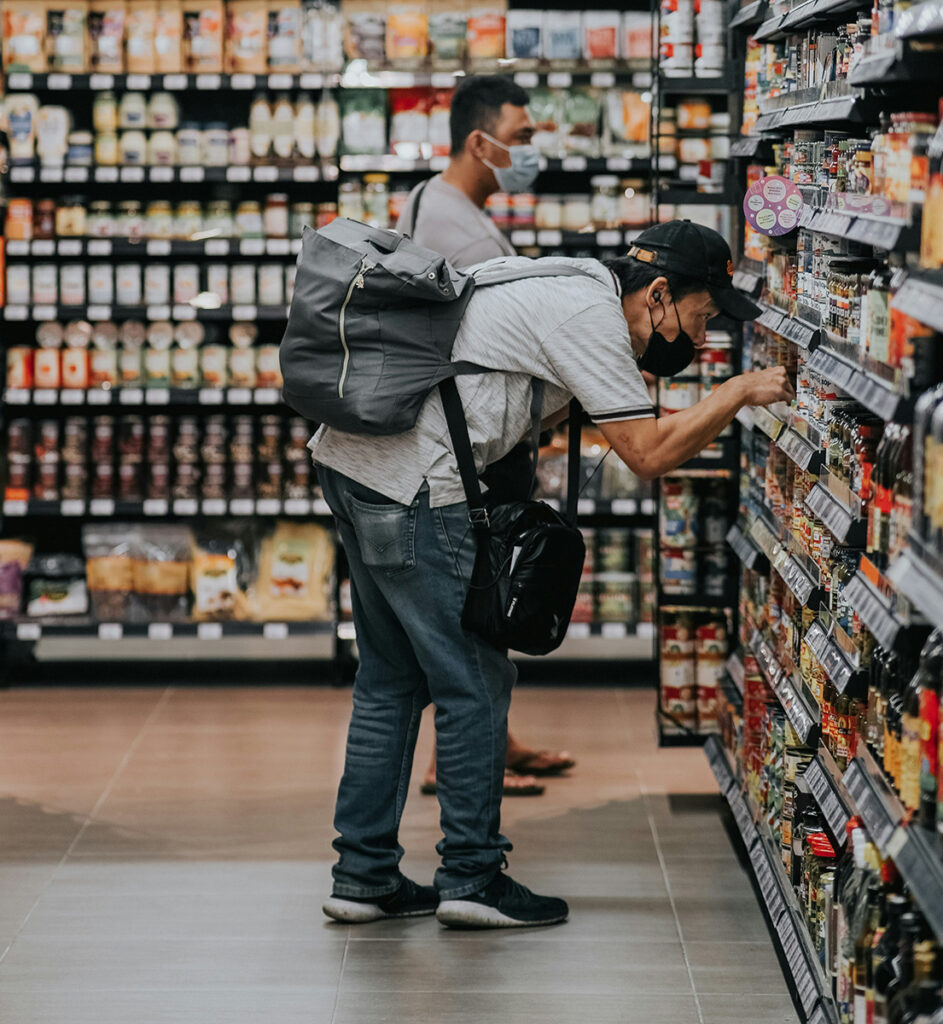 Dos hombres leyendo etiquetas en un supermercado.